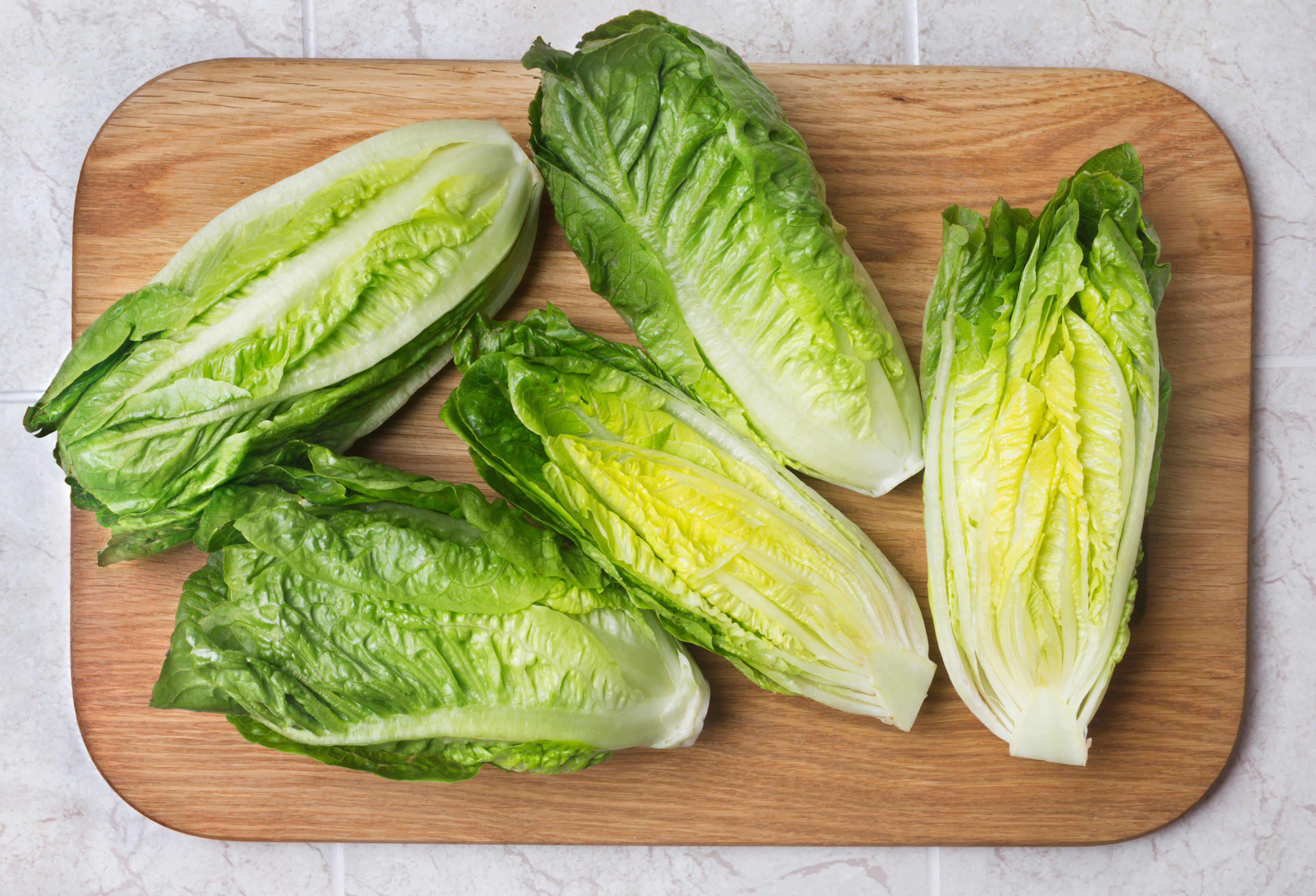 Romaine lettuces on a wooden chopping board 