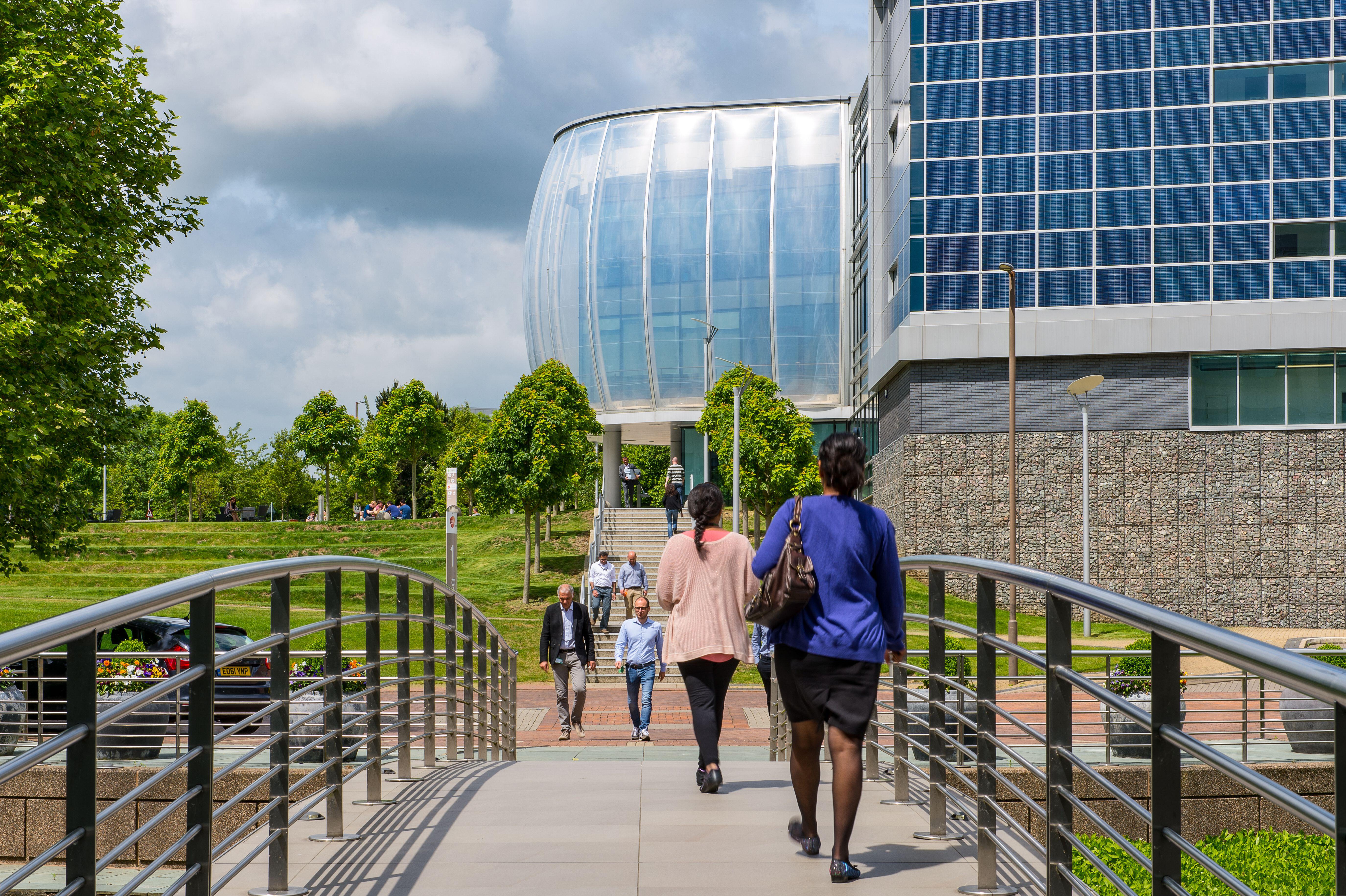 Office workers walking across a footbridge