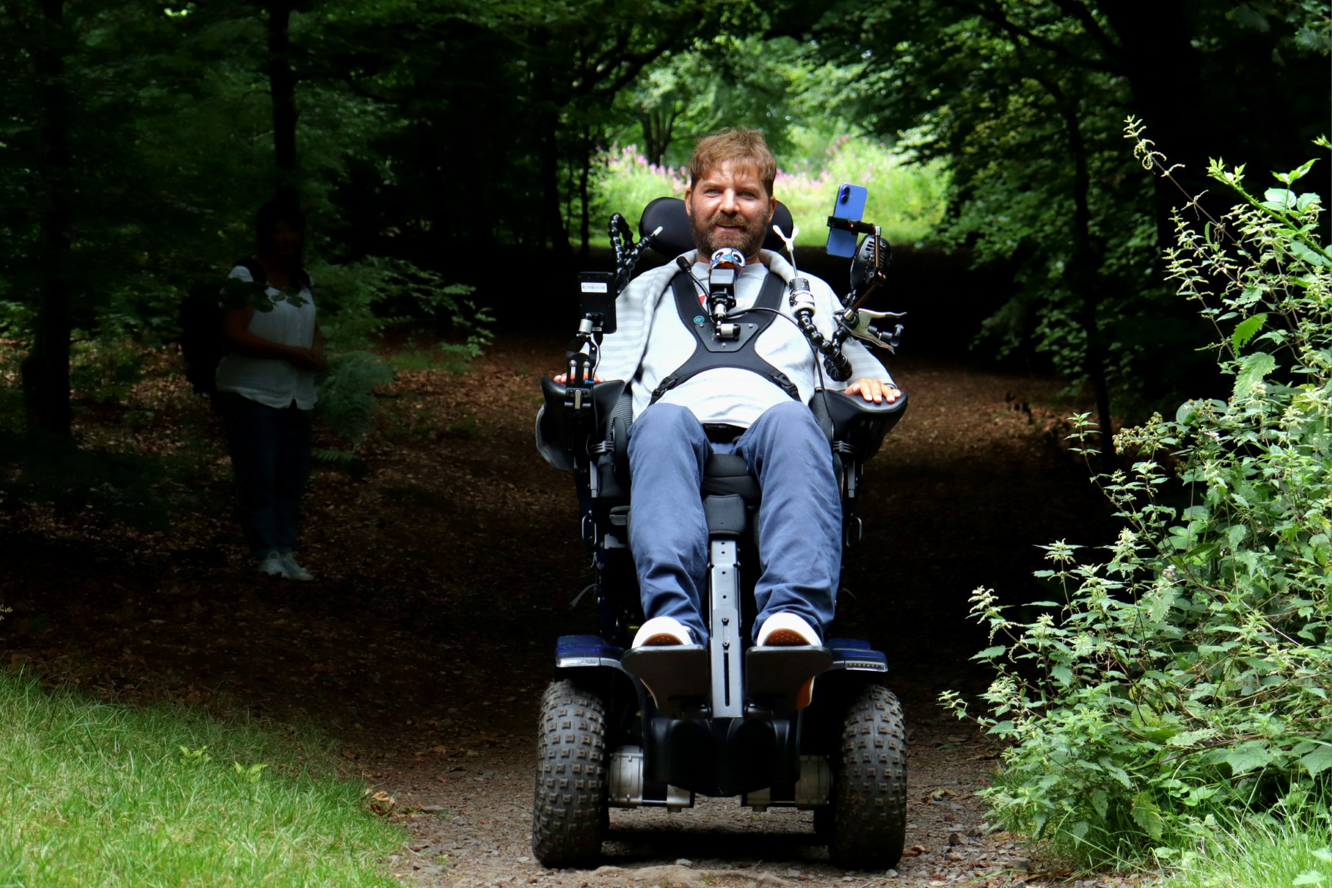 Danny Mavor on his off-road wheelchair travelling through a wooded area