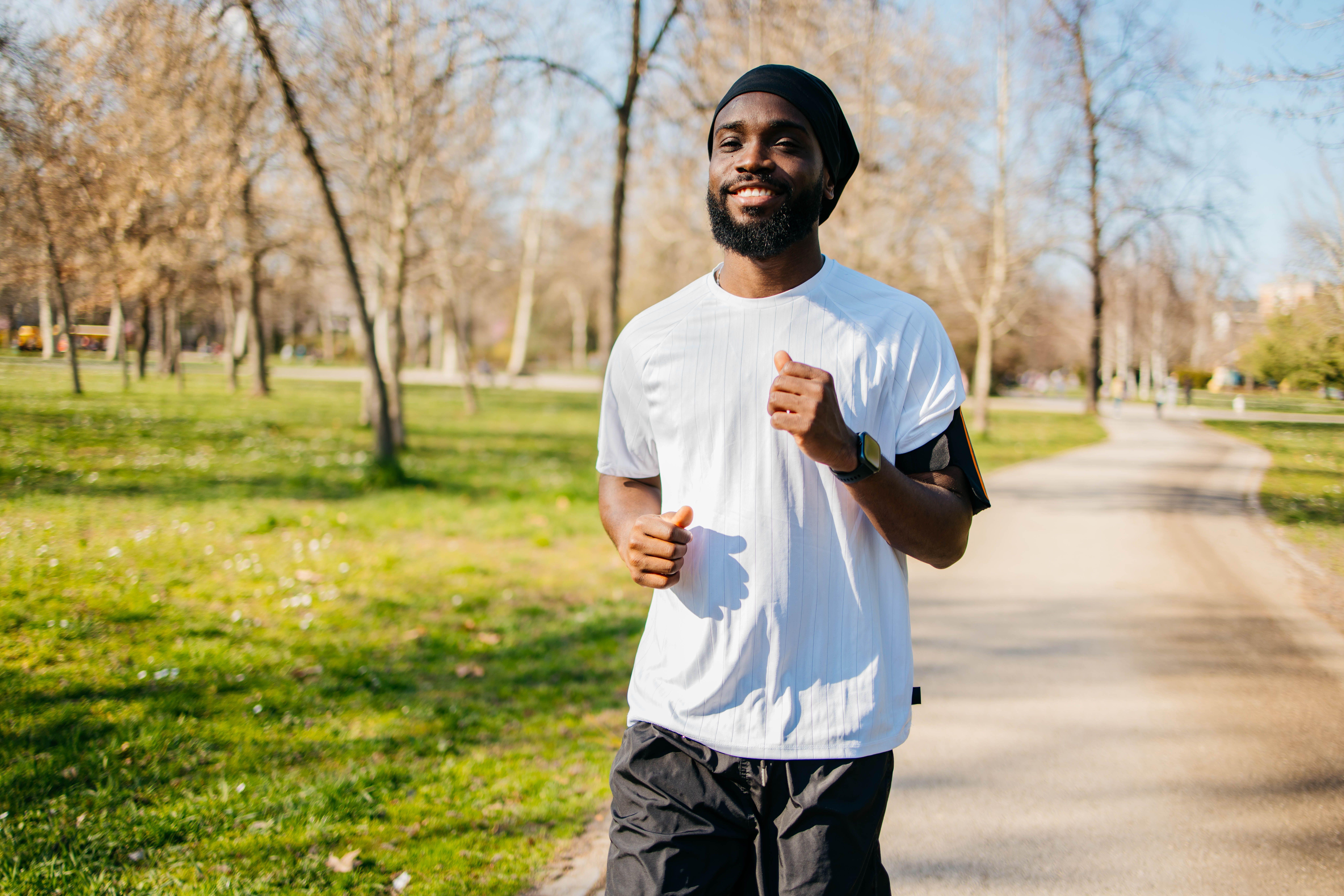 Happy man wearing a white T-shirt while running in a park