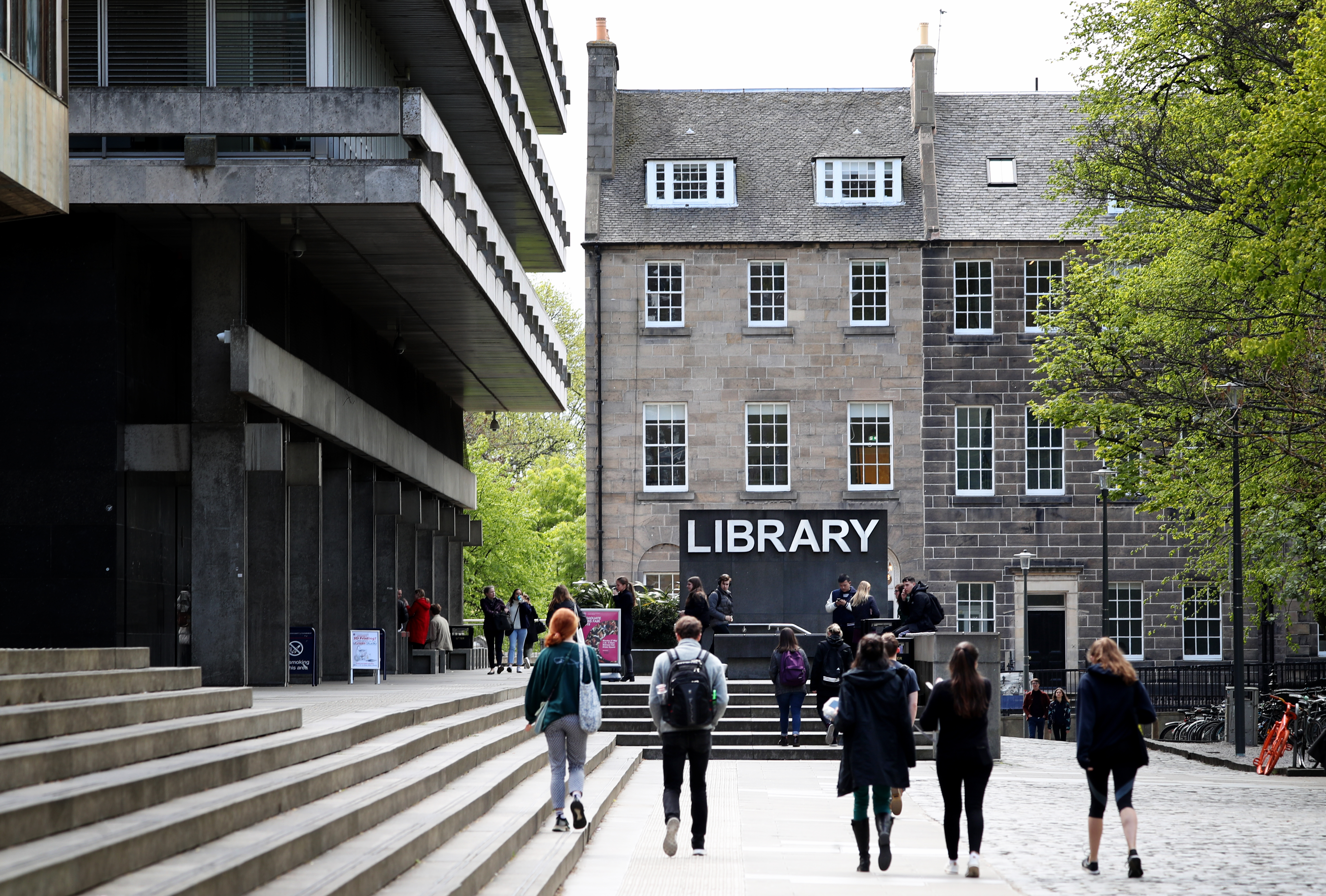 Students walking outside, with a building marked 'library' in the centre of the photo