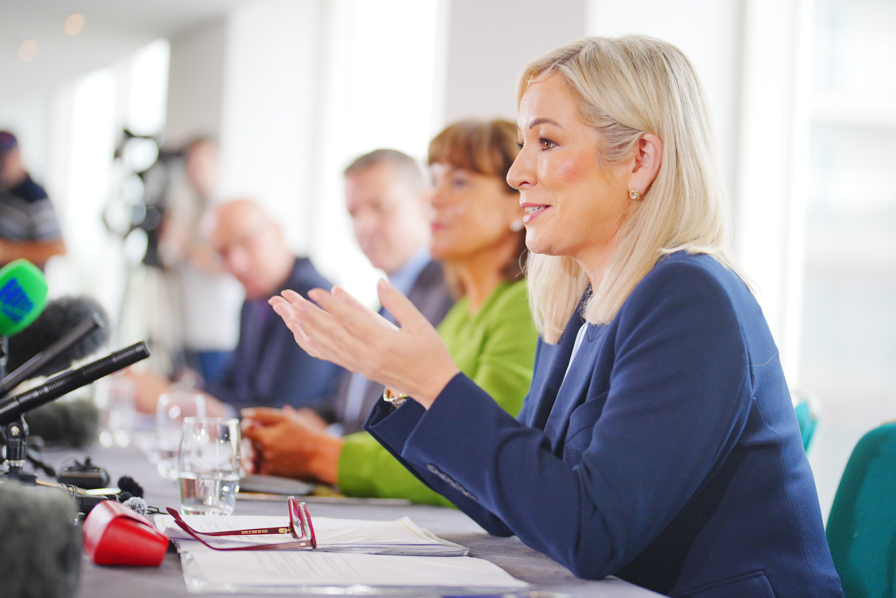 Side view of Michelle O'Neill speaking, while seated at a long table