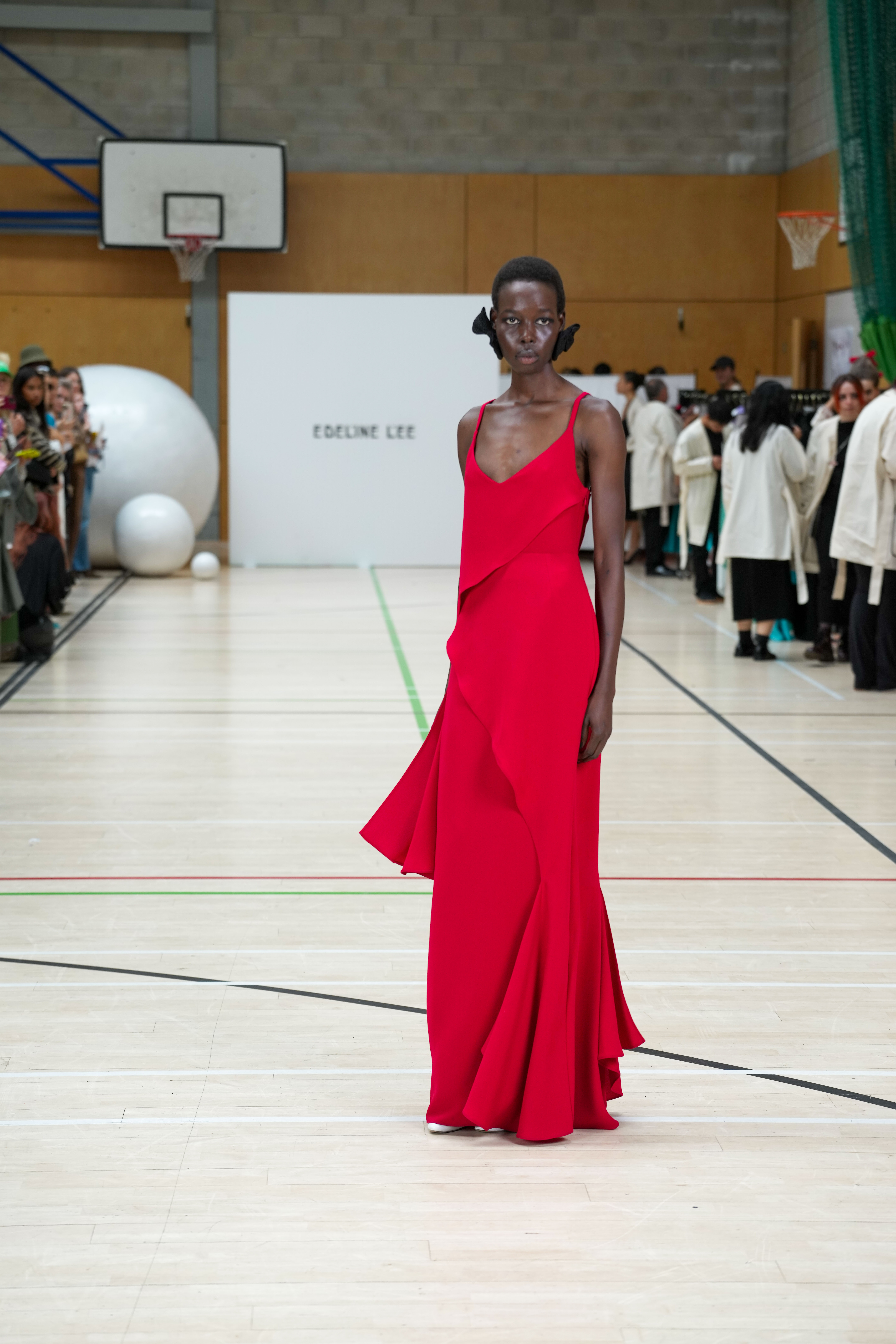 A model on the catwalk wearing a red dress