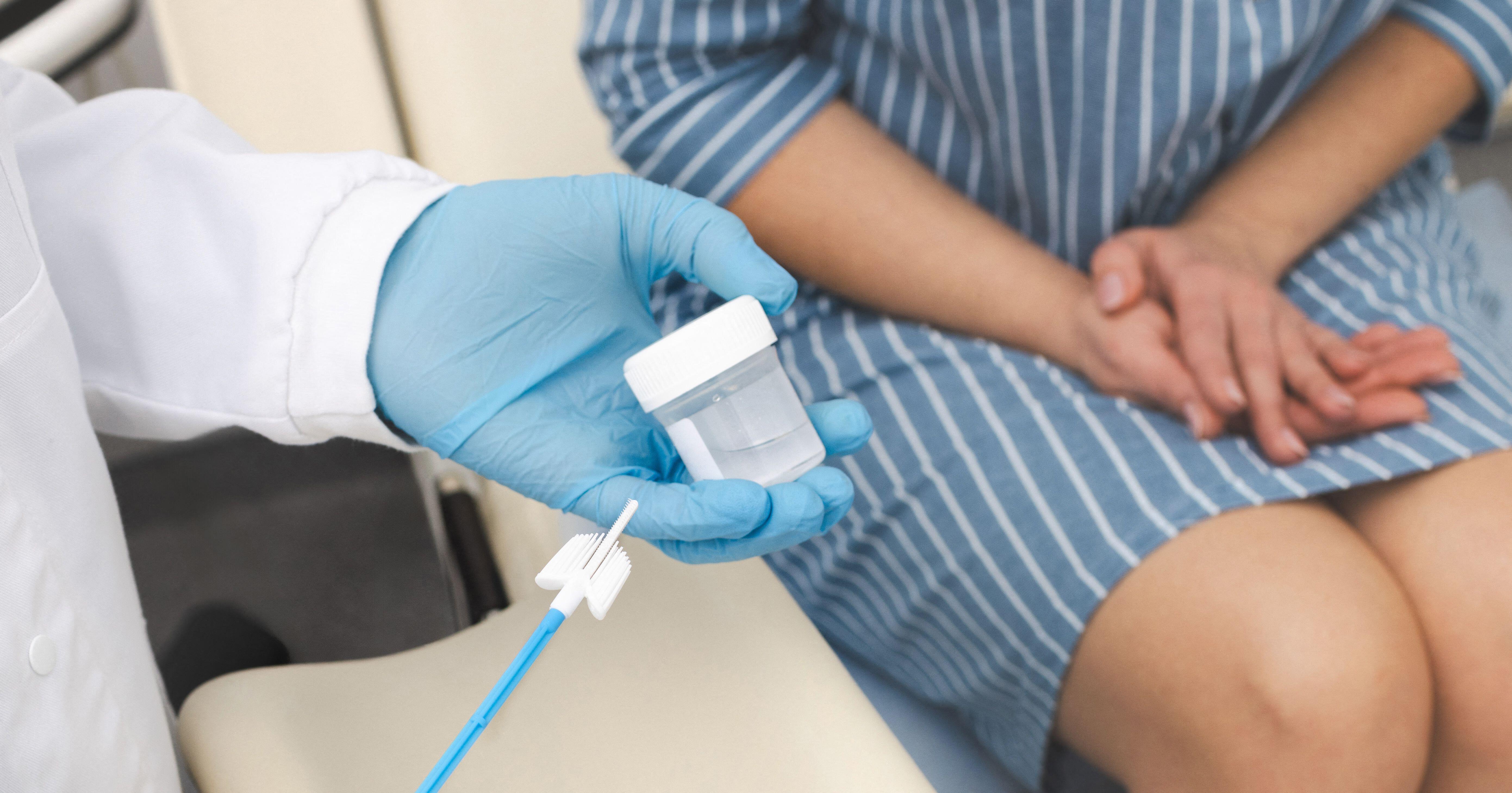 Gynaecologist doctor taking smear for cytology from female patient 