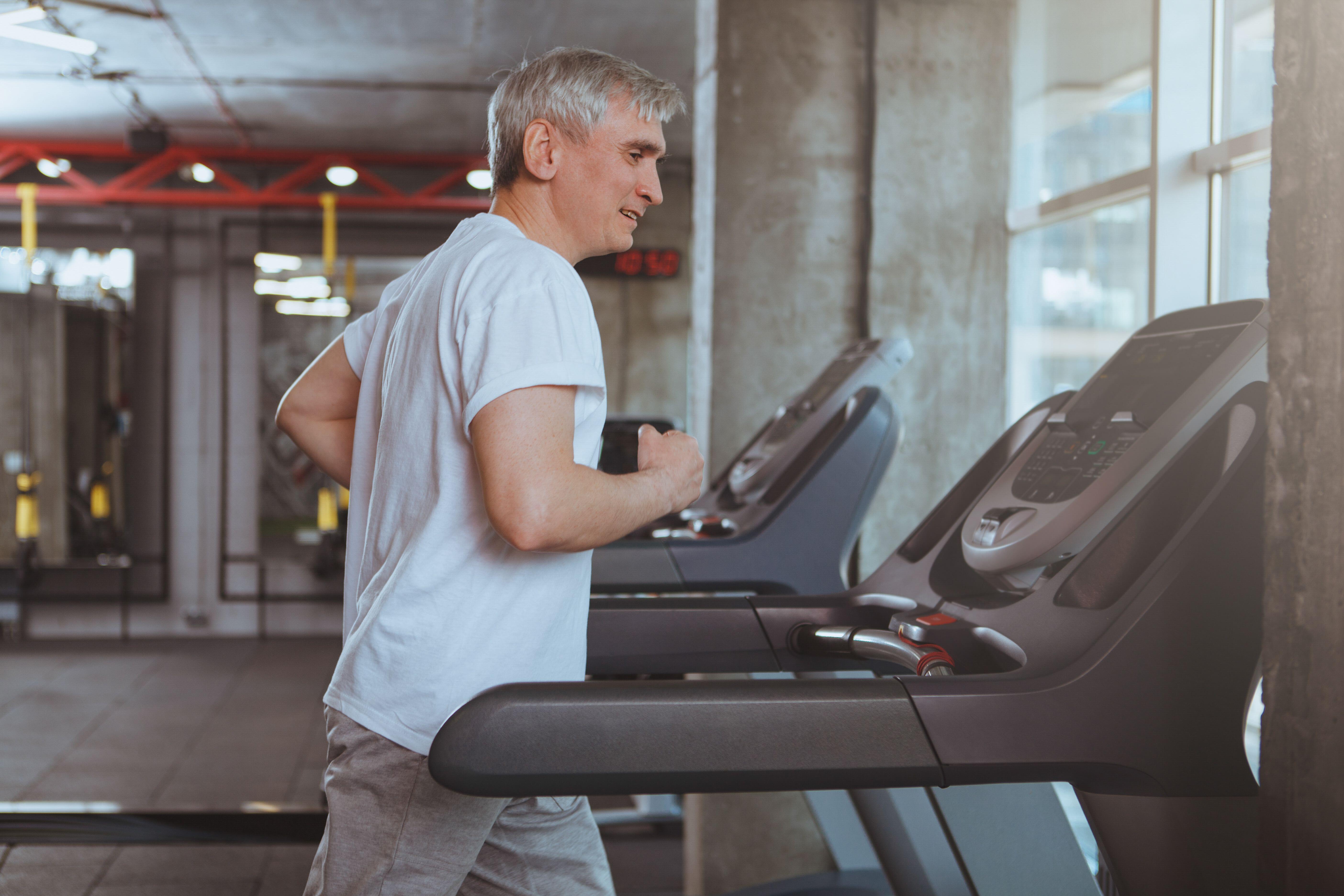 Senior sportsman running on a treadmill at the gym,