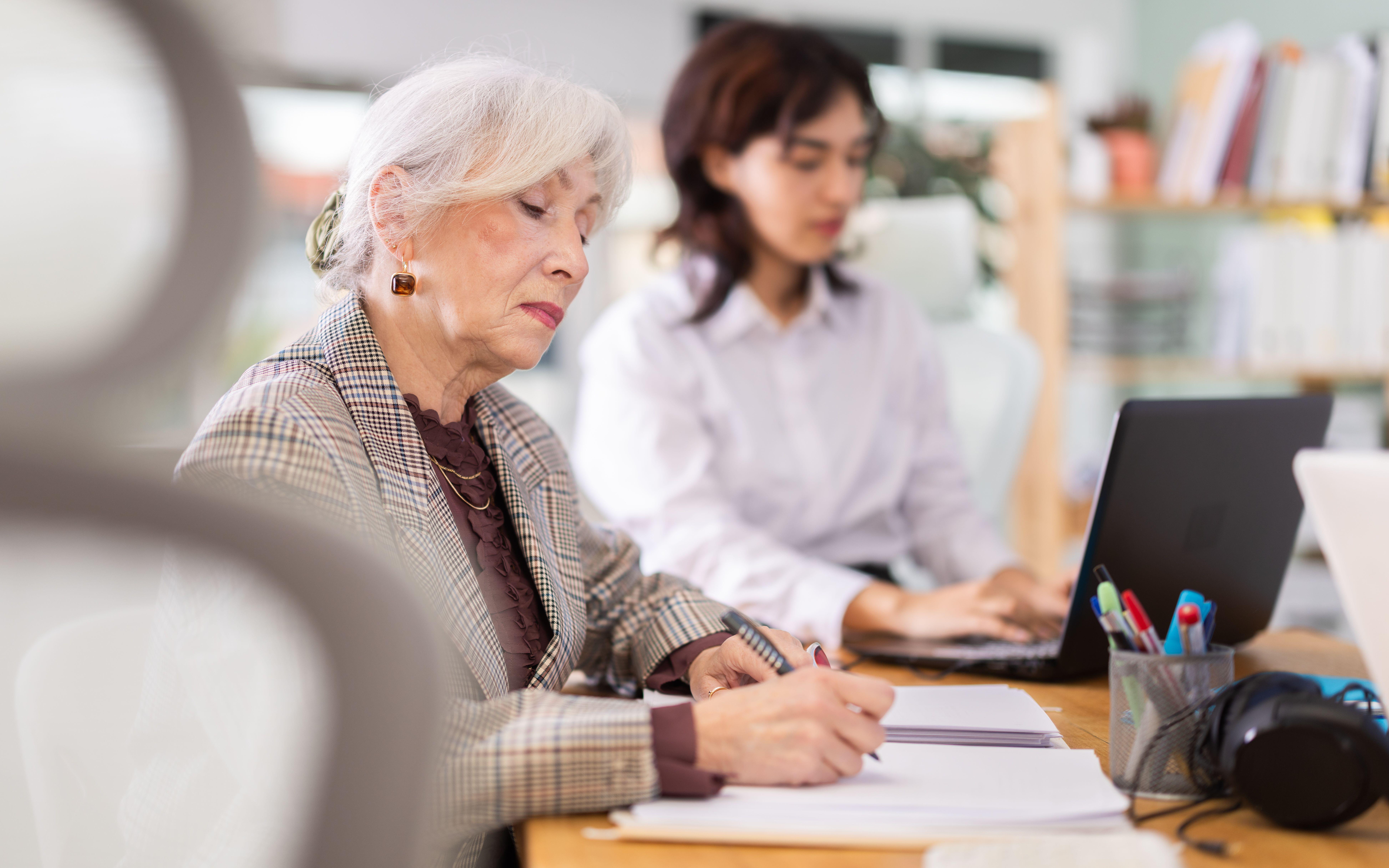 Focused mature woman engaged in paperwork at her workplace