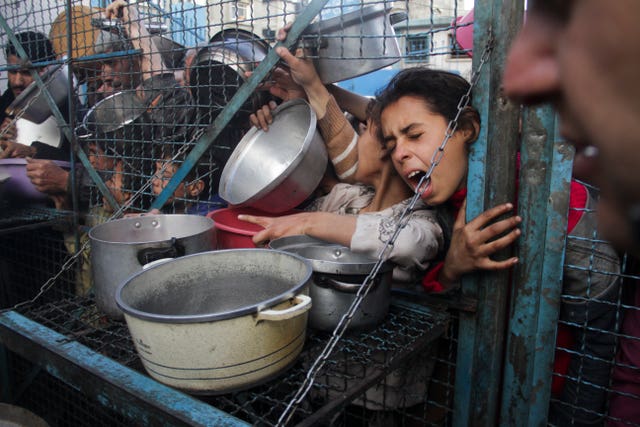 Palestinians line up to receive free meals at the Jabaliya refugee camp in the Gaza Strip