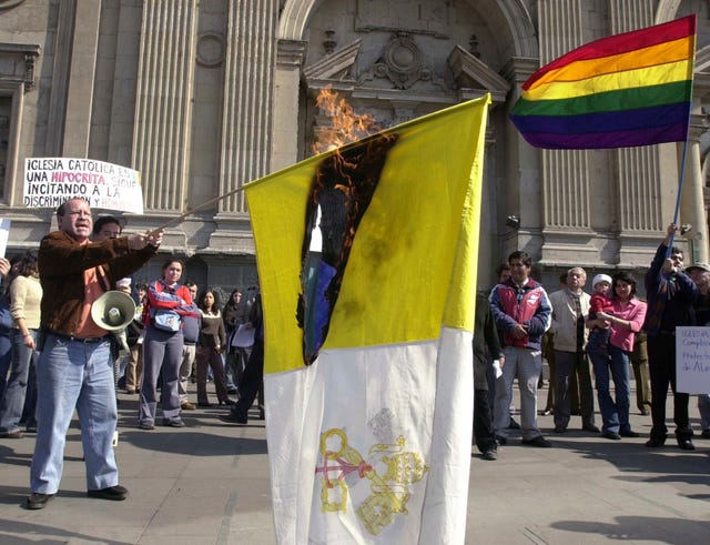 Rolando Jimenez, leader of a Chilean gay rights organisation, holds a flaming Vatican flag during a protest by gay activists against the Roman Catholic Church’s rejection of same-sex marriages, in front of a cathedral in Santiago, Chile, in 2003