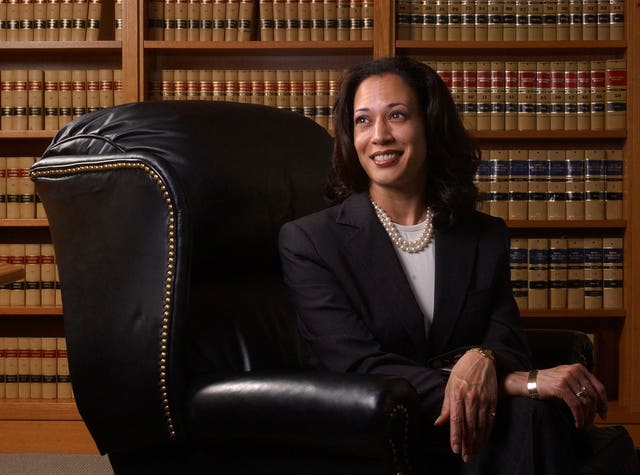 Kamala Harris sitting in armchair in a library