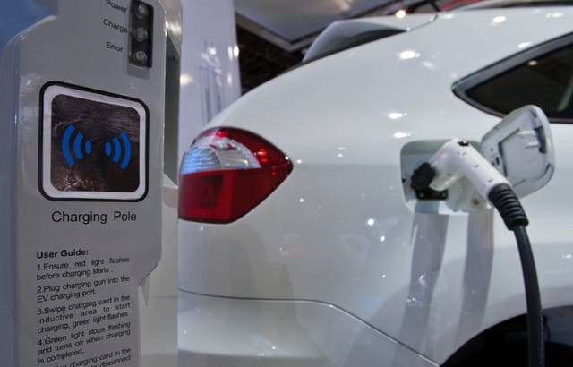 A display shows how the dual-mode electric S6DM sport utility vehicle from Chinese automaker BYD can be plugged into a charging station to recharge its onboard batteries 