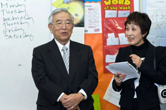 Dr Shoichiro Toyoda, then-honorary chairman of Toyota, with his translator Ms Morita, left, speaks to a classroom at St Bartholomew School in Louisville, Kentucky, during a tour to observe students and parents participating in Toyota’s Family Literacy Programme in 2011