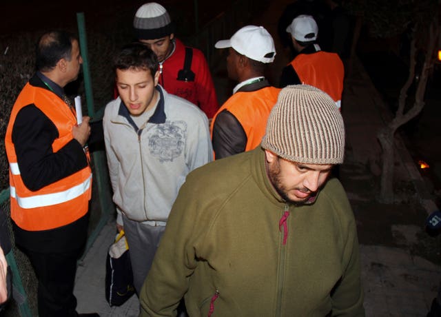 Arab League observers, with orange vests, oversee the releasing of Syrian prisoners as they leave Adra Prison