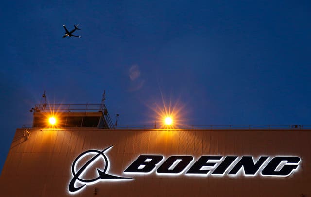 Boeing sign with a plane flying overhead
