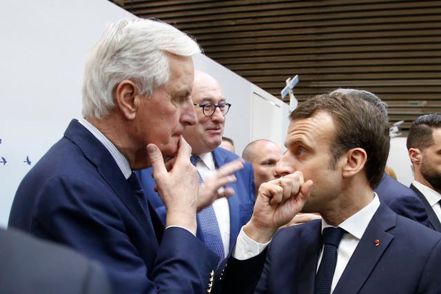 President Emmanuel Macron whispers to then EU chief Brexit negotiator Michel Barnier as he visits the International Agriculture Fair in Paris 