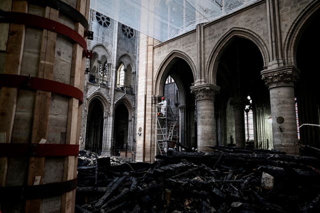 A worker stands on scaffolding during preliminary work inside Notre Dame