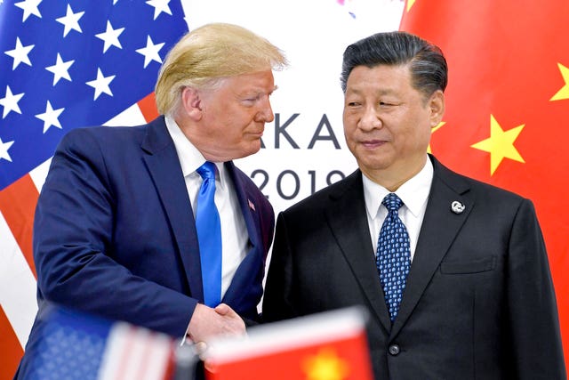 Trump and Jinping shake hands in front of American and Chinese flags