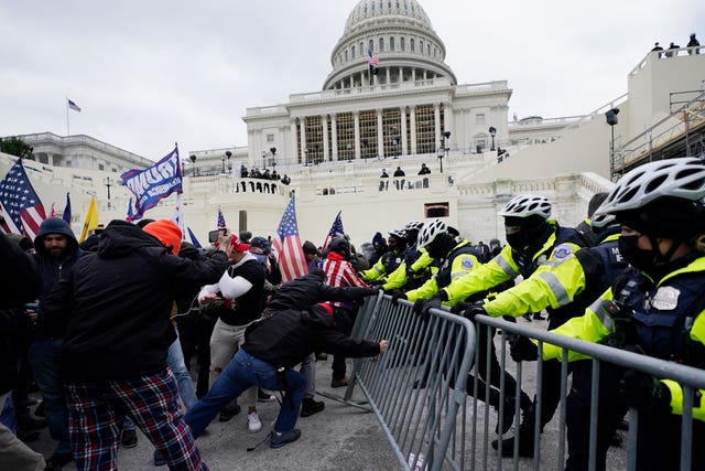 Insurrectionists loyal to president Donald Trump try to break through a police barrier on January 6 2021 at the Capitol in Washington