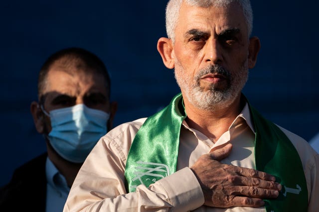 Yahya Sinwar, Palestinian leader of Hamas in the Gaza Strip, places his hand over his heart on stage after greeting supporters at a rally on May 24 2021 in Gaza City, the Gaza Strip