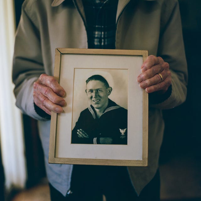 Warren Upton holds a picture of himself as a young serviceman