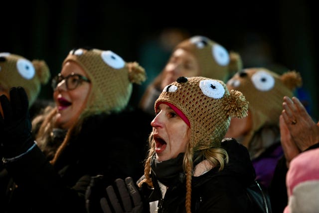 People in a crowd wearing groundhog hats