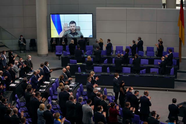 Members of the German parliament Bundestag give Ukraine President Volodymyr Zelensky a standing ovation after he speaks in a virtual address to the parliament at the Reichstag Building 
