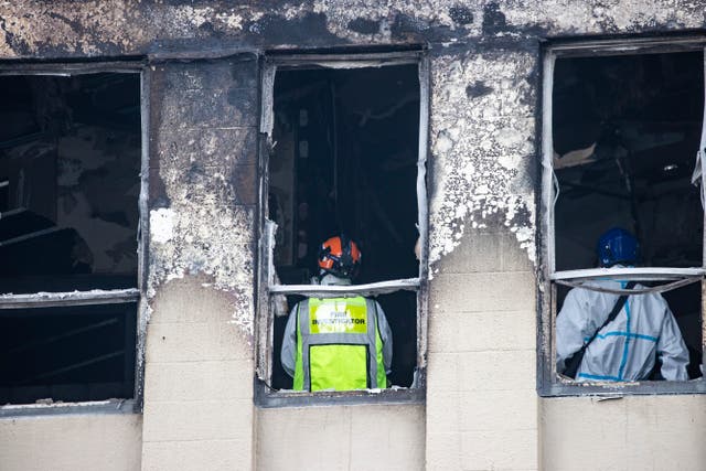 Fire and police investigators inspect inside the hostel 