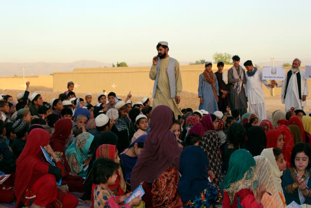 Matiullah Wesa reads to students in the outdoors in the southern Kandahar province of Afghanistan 