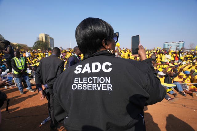 An election observer takes pictures at an opposition campaign rally in Harare