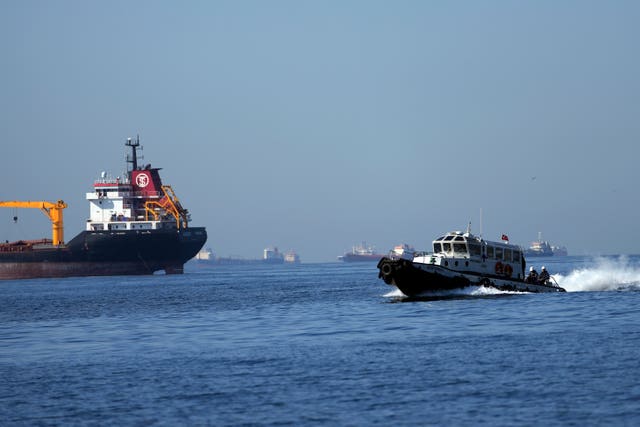 Inspectors on boat head to bulk carrier