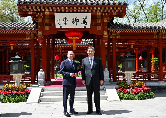 Chinese President Xi Jinping, right and German Chancellor Olaf Scholz pose for a photo in Beijing, China