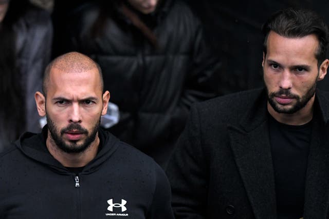 Andrew Tate, left, and his brother Tristan leave after appearing at the Court of Appeal in Bucharest, Romania