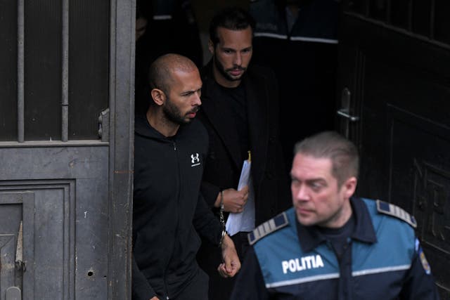 Andrew Tate, left, and his brother Tristan, leave after appearing at the Court of Appeal in Bucharest, Romania