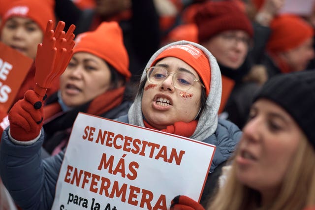 A protestor shouts slogans while holding a placard reading “We need more nurses” during a nursing strike outside Mount Sinai Hospital