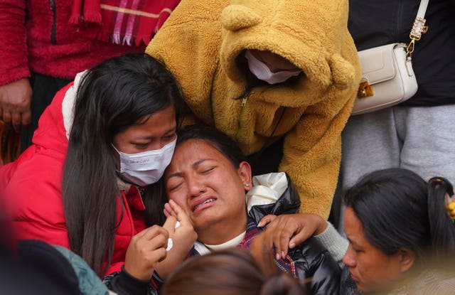 A woman cries as she waits to receive the body of a relative at a hospital in Pokhara, Nepal