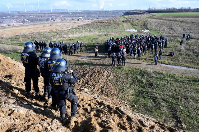 Police officers surround a group of activists and coal opponents on the edge of the Garzweiler II lignite open pit mine during a protest by climate activists following the clearance of Luetzerath, Germany 