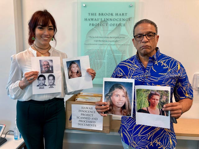 University of Hawaii law school student Skye Jansen, left, and Hawaii Innocence Project co-director Kenneth Lawson pose with photos related to the 1991 murder of Dana Ireland