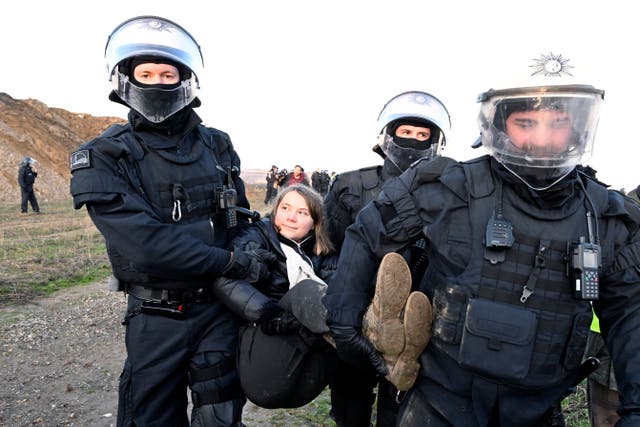 Police officers carry Swedish climate activist Greta Thunberg away from the edge of the Garzweiler II opencast lignite mine during a protest action by climate activists after the clearance of Luetzerath, Germany