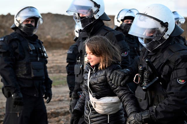Police officers lead Swedish climate activist Greta Thunberg away from the edge of the Garzweiler II opencast lignite mine during a protest action by climate activists after the clearance of Luetzerath, Germany