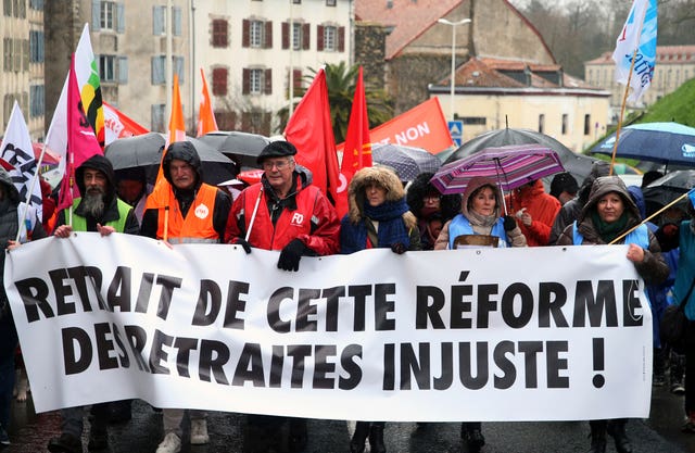 Demonstrators from unions hold a banner reading in French “withdrawal of this unfair pension reform” during a demonstration in Bayonne, southwestern France