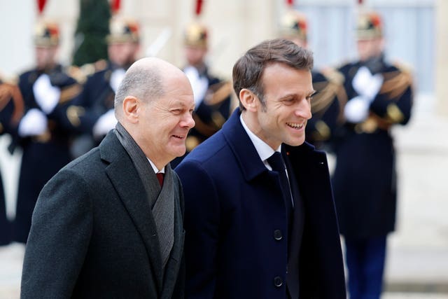 German chancellor Olaf Scholz, left, and French president Emmanuel Macron walk in the courtyard of the Elysee Palace 