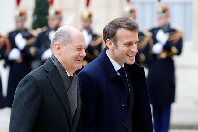 German Chancellor Olaf Schulz (left) and French President Emmanuel Macron walk in the courtyard of the Elysee Palace 