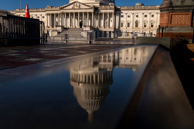 The dome of the US Capitol Building is visible in a reflection on Capitol Hill in Washington