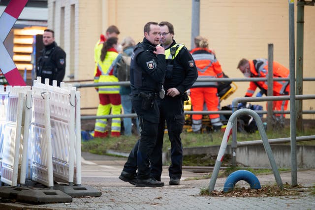 Police officers stand guard as emergency services work at Brokstedt station in Brockstedt, Germany