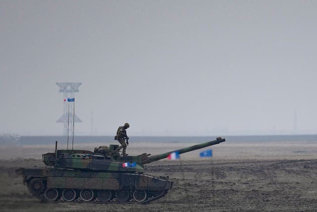 A French serviceman stands on a Leclerc main battle tank during the exercise