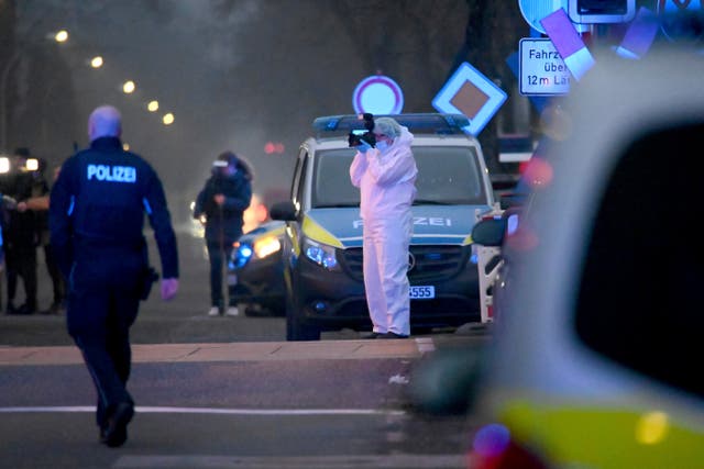 Police and forensic teams work at a level crossing near Brokstedt station in Brockstedt, Germany