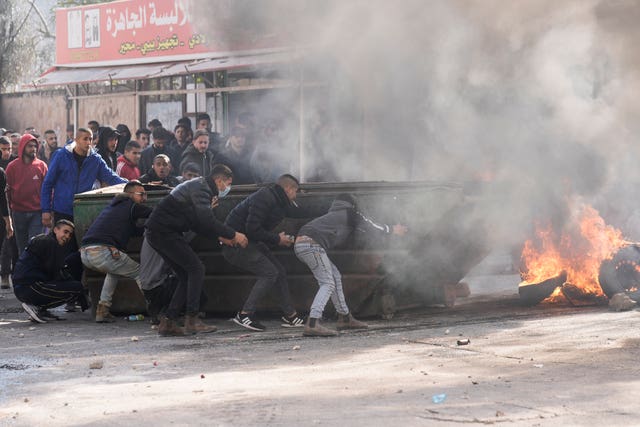 Palestinians clash with Israeli forces following an army raid in the West Bank city of Jenin