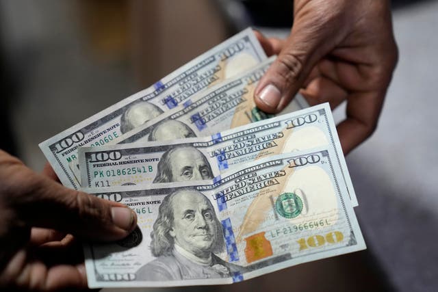 A Pakistani money trader shows US 100 dollar notes at a currency exchange office in Lahore, Pakistan 