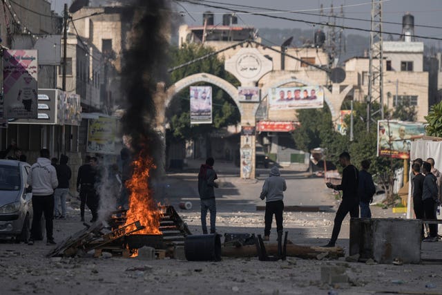 Palestinians clash with Israeli forces following an army raid in the West Bank city of Jenin