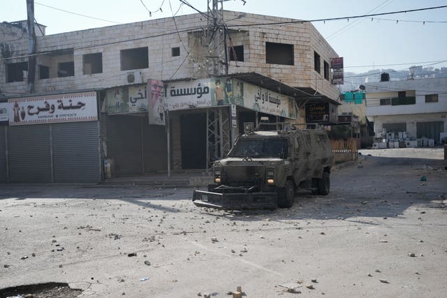 Israeli military vehicles are seen during the raid