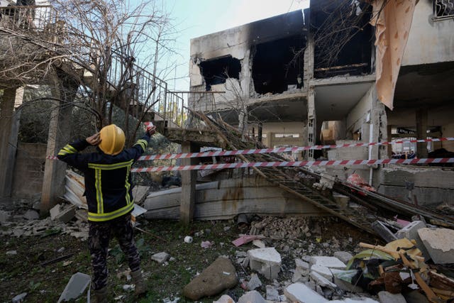 Palestinian rescuers inspect the site of a damaged building following an Israeli forces raid in the West Bank city of Jenin, Thursday, Jan. 26, 2023